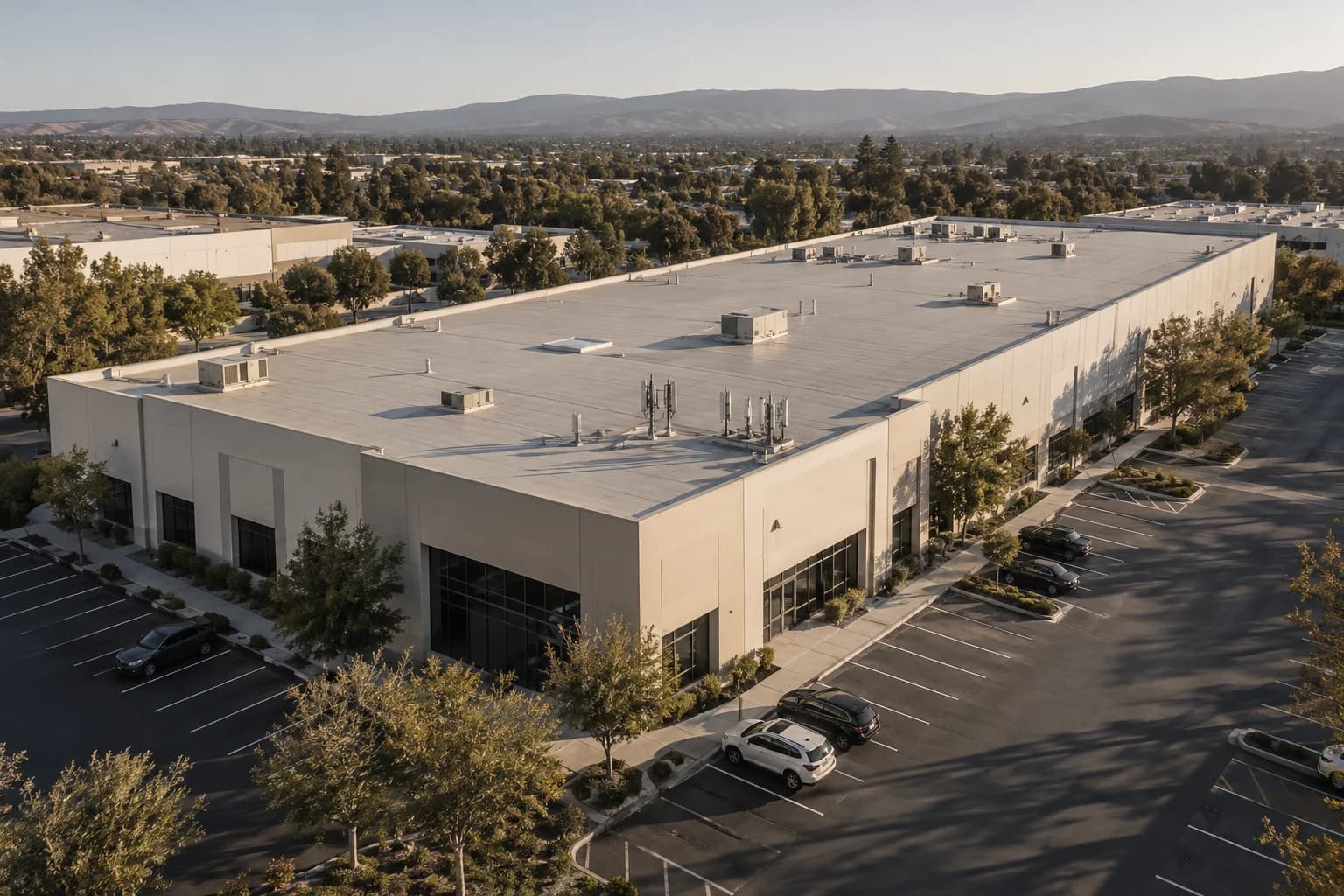 Illustrative aerial view of a commercial rooftop with compact infrastructure and surrounding parking